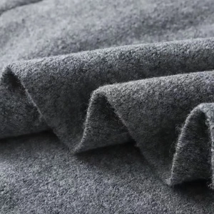 Macro view of gray knitted fabric texture showing soft wool blend material and stitching
