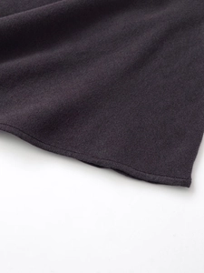 Vista macro del tessuto a maglia grigio antracite con trama fine e bordo rifinito morbido