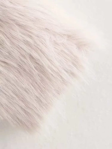 Close-up of soft faux fur fabric texture in pale pink color for winter coat