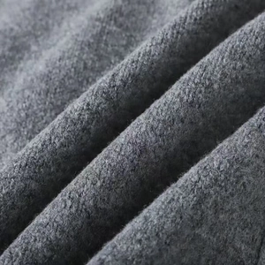Close-up of grey knitted cardigan fabric showing soft texture and high-quality wool fibers