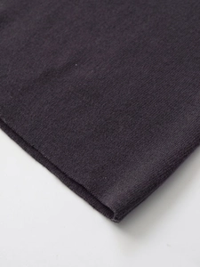 Dettaglio macro del tessuto a maglia grigio scuro che mostra trama fine e materiale