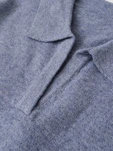 Detailed view of soft light blue knit polo sweater showing lapel collar and wool texture