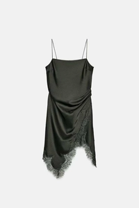 Détail de la robe en satin avec dentelle noire délicate et plis latéraux élégants