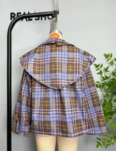 Dettaglio del collo a scialle a quadri oversize e chiusura con bottone sul retro della giacca
