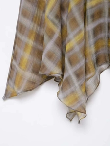 Close-up of semi-transparent yellow and grey plaid fabric with artistic gradient texture