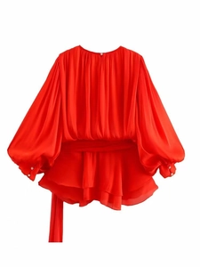 Detail of red lantern sleeves with elegant pearl buttons and silky chiffon texture
