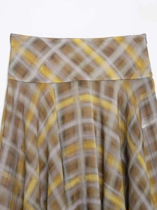 Macro detail of glossy plaid midi skirt with silk texture and hidden zipper closure