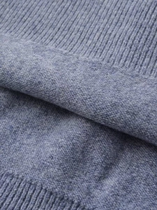 Macro view of blue knit sweater fabric showing ribbing and fine stitching texture