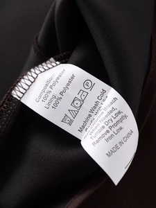Detail view of clothing label showing 100% polyester fabric and washing instructions
