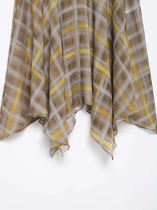 Detail of yellow and grey plaid chiffon skirt featuring irregular high-low hemline