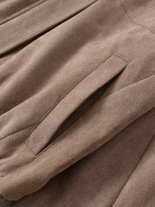 Detailed macro view of the brown suede jacket pocket with professional stitching