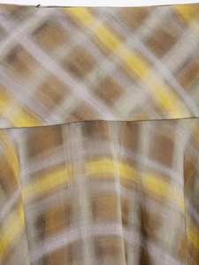 Close-up detail of artistic ginger and coffee plaid pattern with smooth draping texture