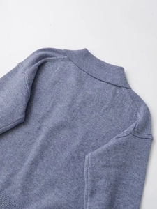 Detail shot of dusty blue knit sweater showing lapel collar and thick wool texture