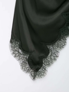 Gros plan détaillé de l'ourlet en satin noir avec dentelle florale et franges de cils