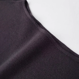 Dettaglio ravvicinato dell'abito in maglia scura con trama premium e cuciture fini