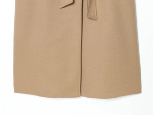 Detail of camel wool coat hem with vertical stitching and matching waist tie texture