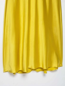 Detailansicht des leuchtend gelben Seidensatin-Saums an diesem eleganten Midikleid