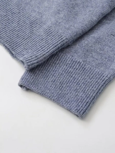 Detail of ribbed cuff on blue knit sweater showing thick texture and fine stitching