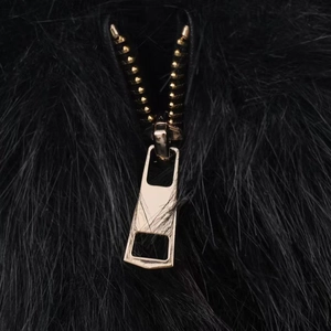 Short faux fur jacket in black featuring a stand collar and gold metal zipper closure