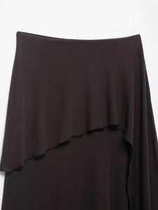 Detailed view of dark brown layered knit fabric with wavy asymmetric ruffled edges