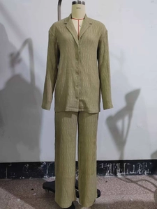 Détail de la texture plissée vert clair sur un ensemble chemise et pantalon