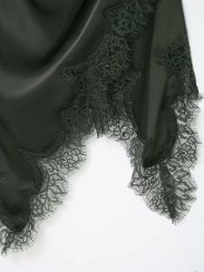 Détail d'une robe en satin noir avec dentelle florale délicate et finitions raffinées