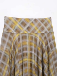 Close-up of yellow and taupe plaid skirt featuring invisible side zipper and fine fabric