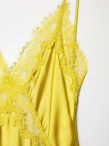 Detail eines gelben Seidensatin-Camisoles mit feiner Wimpernspitze und elegantem V-Ausschnitt