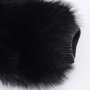 Close-up of black faux fur sleeve with textured leather cuff detail on a winter jacket