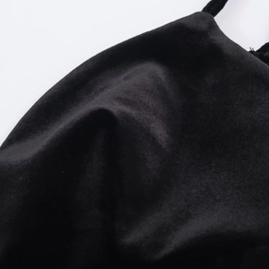 Close-up of high-quality black velvet fabric texture with soft glossy sheen and elegant folds