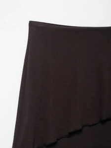 Detailed macro view of dark brown knitted fabric featuring elegant lettuce edge hem style