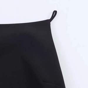 Detailed close-up of the fine stitching and thin strap on a black summer top