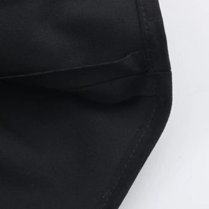Macro detail of black suede dress showing clean stitching and soft fabric texture