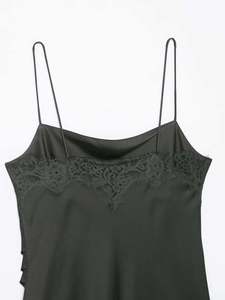 Détail de robe nuisette en satin noir avec dentelle de cils délicate et fines bretelles