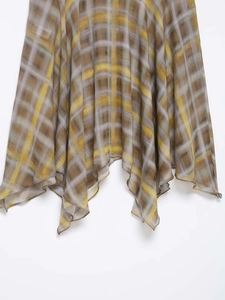 Detail of elegant yellow and grey plaid pattern on irregular flowing midi skirt fabric