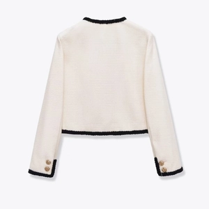 Back view of a chic cream tweed jacket with black knit trim and gold buttons on cuffs
