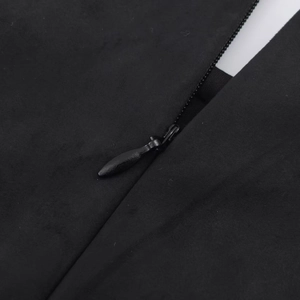 Detailed close-up of a hidden zipper on a black suede layered dress with metal pull