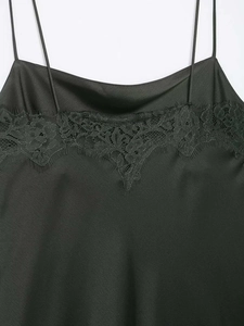 Détail d'un caraco en satin noir avec de la dentelle délicate au niveau du décolleté