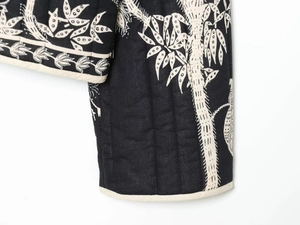 Detail of vertical quilting and bamboo leaf embroidery on the black cotton jacket hem
