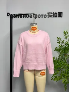 Detail of pink crewneck sweater showing ribbed cuffs and soft flat-knit texture