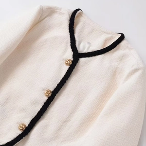Elegant cream tweed jacket with black trim and gold buttons for women in a classic style