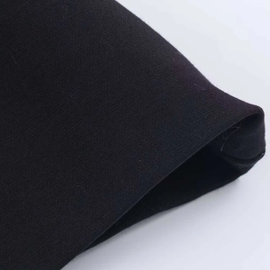 Detailed macro view of black twill fabric texture and neat hem stitching for camisole top