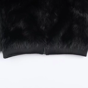 Detail of black faux fur jacket showing the ribbed hem and durable metal zipper closure