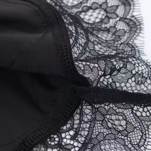 Detailed view of black floral lace fabric with eyelash edges on a stylish dress