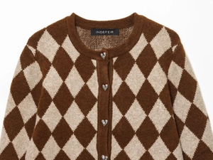 Detail der Strickjacke mit Rautenmuster, herzförmigen Silberknöpfen und Rundhalsausschnitt