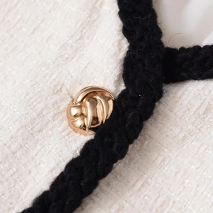 Chic tweed jacket with black woven trim and decorative gold metallic button detail