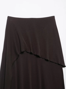 Detailed view of the irregular layered ruffles on a dark brown knitted skirt fabric