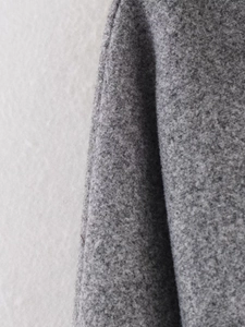 Close-up of grey melange wool fabric texture and clean stitching on a winter coat