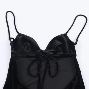 Detail of silk-satin black camisole dress featuring thin straps and lace-up V-neckline