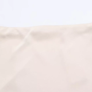 Primer plano detallado de la falda midi beige que muestra la textura lisa y el acabado